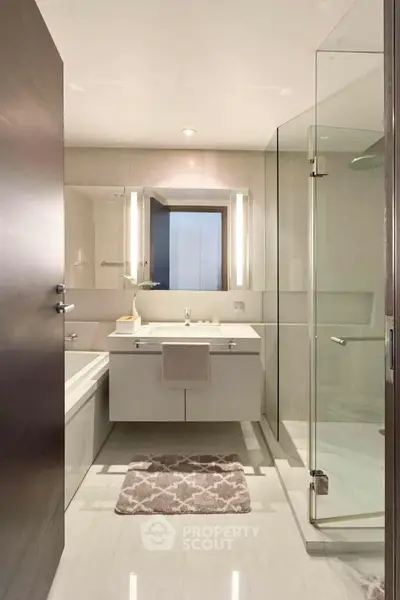 Modern bathroom with glass shower and sleek vanity in luxury apartment
