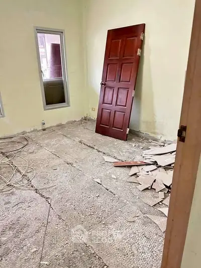 Room under renovation with removed door and debris on the floor