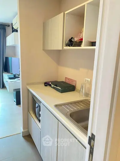 Compact kitchen area with modern cabinetry and sink in a cozy apartment
