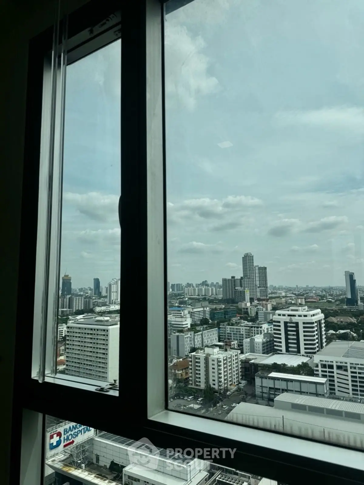 Stunning cityscape view from a high-rise window, showcasing urban skyline and clear skies.