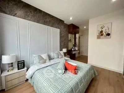 Luxurious bedroom with elegant decor and modern furnishings, featuring a stylish accent wall and cozy bedding.