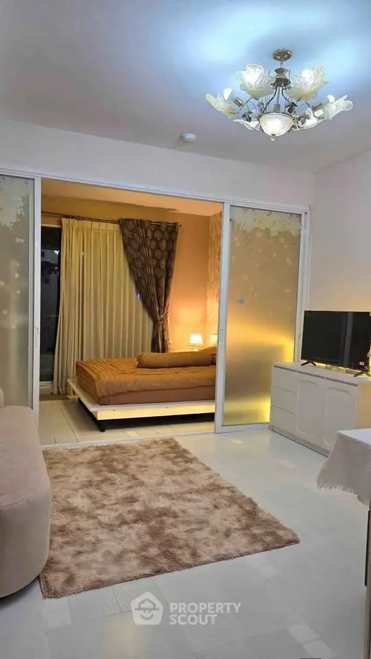 Cozy living room with elegant lighting and view into a stylish bedroom