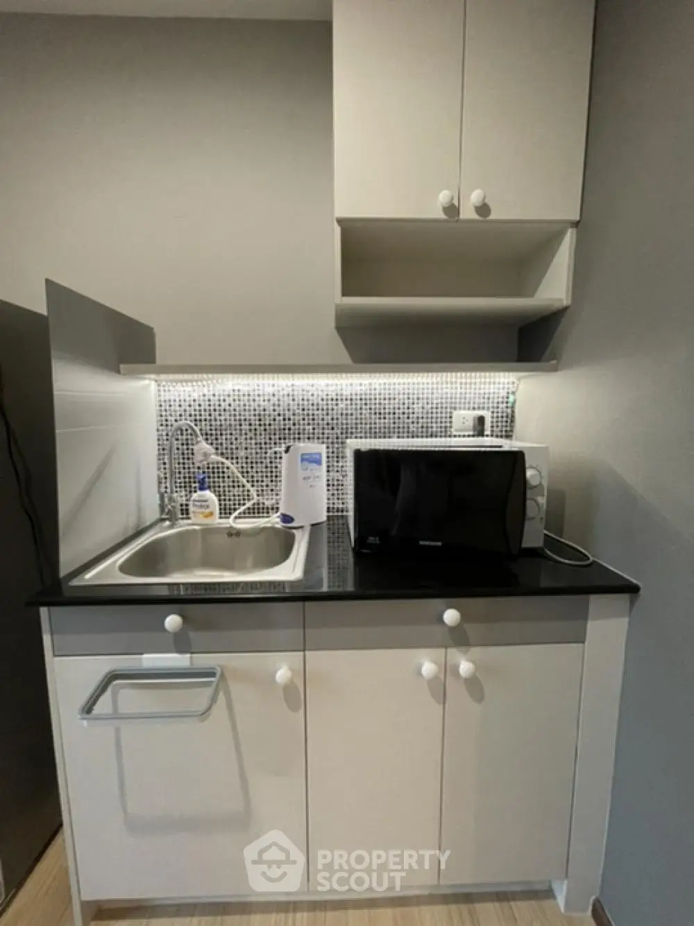 Compact modern kitchen with sleek cabinetry and built-in microwave