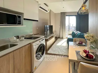 Modern open-plan living room with kitchen, featuring city view and stylish decor.
