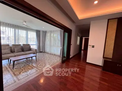 Spacious living room with elegant wooden flooring and large windows for natural light.