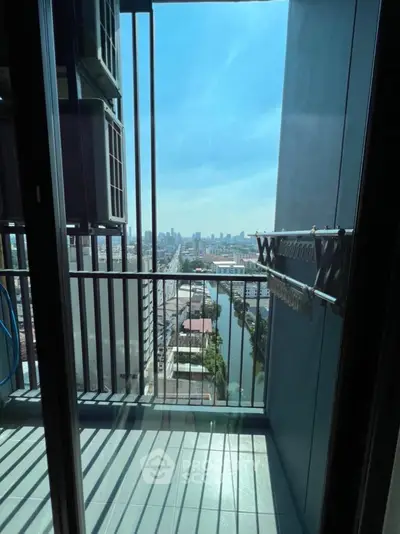 Stunning city view from a modern high-rise balcony with sleek railing.