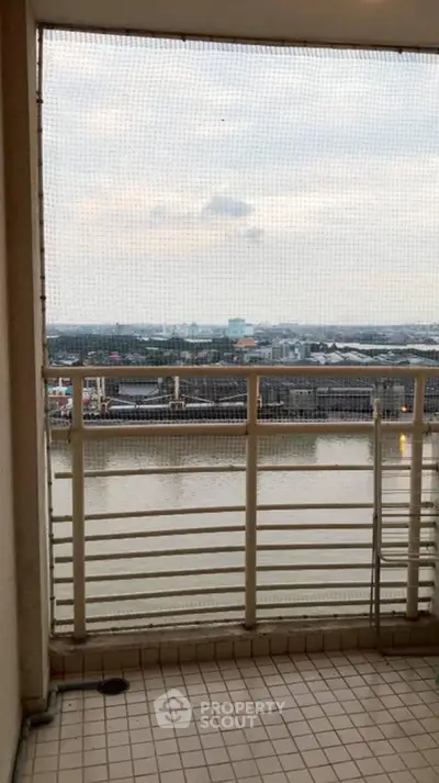 Scenic balcony view overlooking a serene river and cityscape, perfect for relaxation.