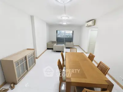Spacious open-plan living and dining area with modern furniture and large windows.