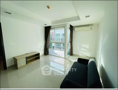 Bright modern living room with large window and sleek furniture in urban apartment.