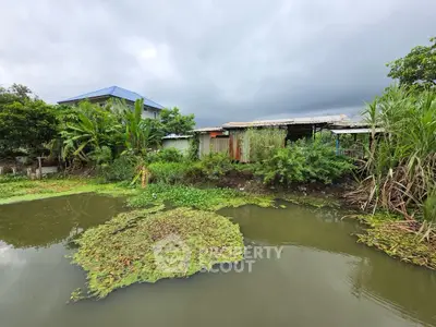 Charming rural property with lush greenery and serene water feature, perfect for nature lovers.