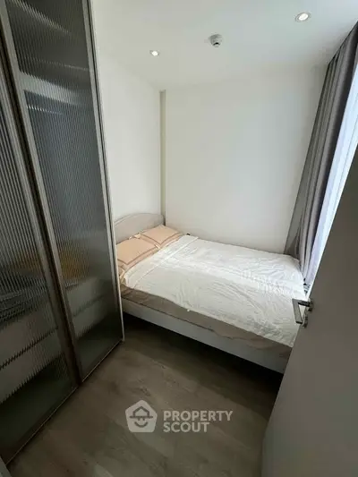 Cozy bedroom with modern design and ample natural light, featuring a comfortable bed and sleek flooring.