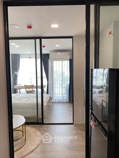 Modern apartment interior with glass sliding doors, cozy bedroom, and stylish living area.