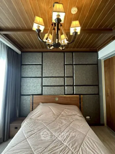 Luxurious bedroom with elegant chandelier and modern paneling, perfect for a cozy retreat.