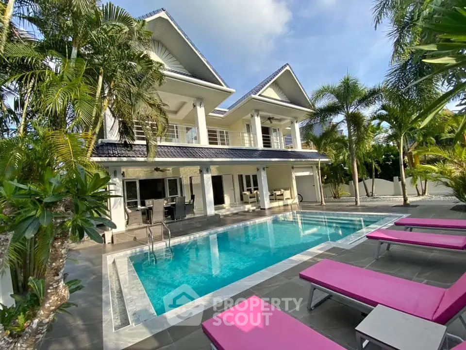 Luxurious villa with stunning pool and lush tropical landscaping, perfect for relaxation and entertainment.