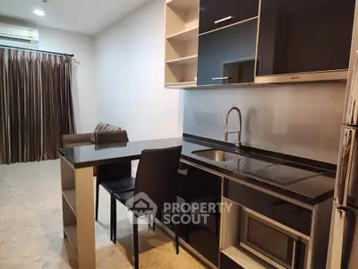 Modern kitchen with sleek black cabinetry and open layout in stylish apartment