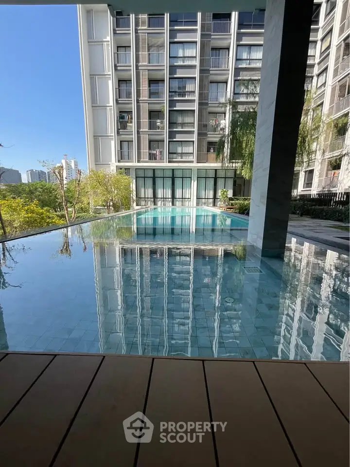 Luxurious apartment building with stunning pool and modern architecture, perfect for urban living.