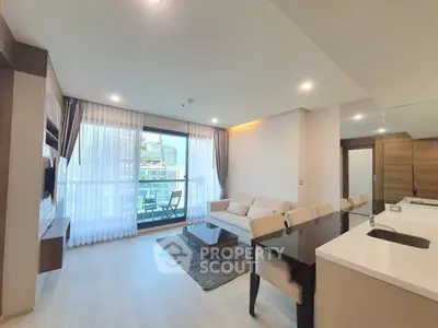 Modern living room with open kitchen and balcony view in luxury apartment.
