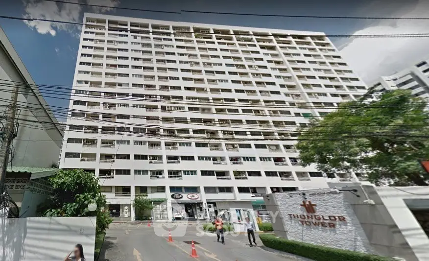 Thonglor Tower exterior view showcasing high-rise building with multiple balconies and entrance.