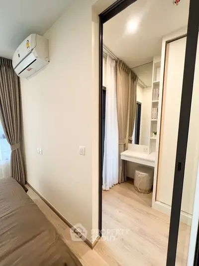 Modern bedroom with ensuite vanity area and air conditioning, featuring sleek design and natural light.