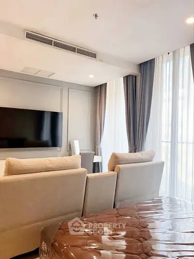 Modern living room with large windows and stylish furniture, perfect for relaxation and entertainment.