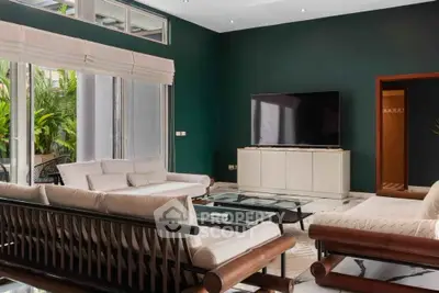 Spacious modern living room with large TV and stylish furniture, perfect for relaxation and entertainment.