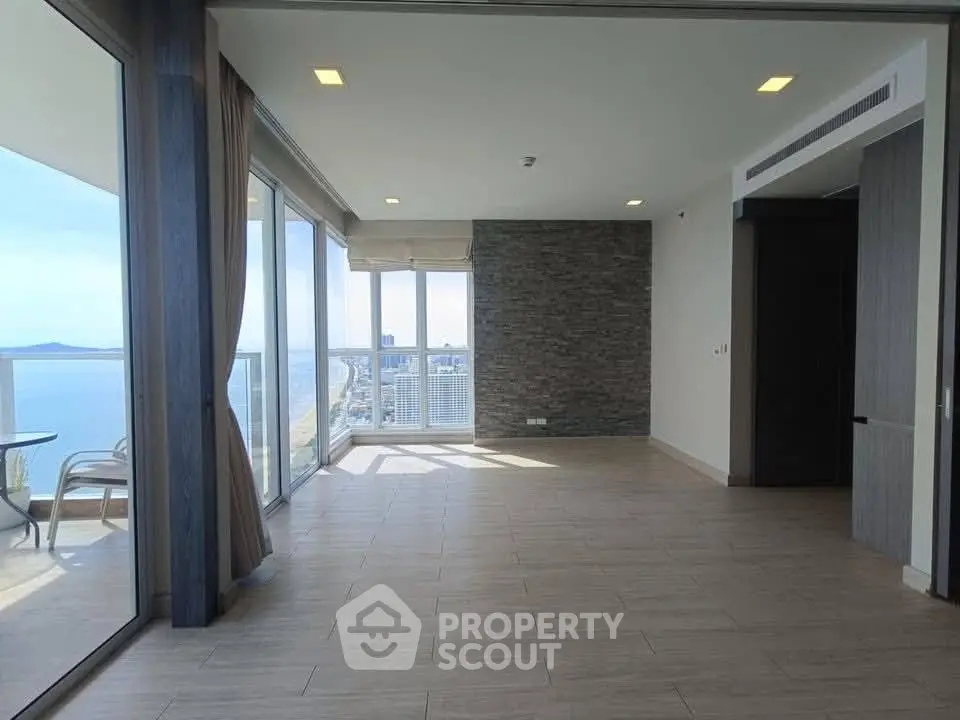 Spacious living room with stunning ocean view and large balcony access.