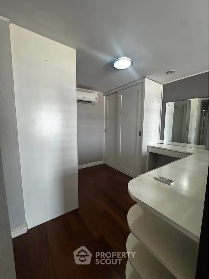 Spacious walk-in closet with wooden flooring and modern design