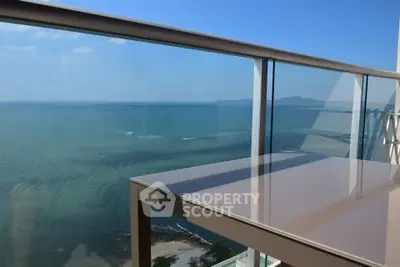 Stunning ocean view from a modern balcony with glass railing, perfect for relaxation.
