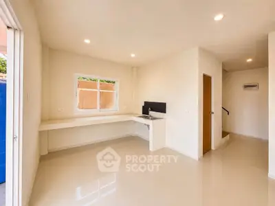 Spacious modern interior with sleek flooring and ample natural light, perfect for versatile living space.