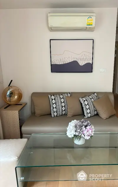 Modern living room with stylish sofa, glass coffee table, and wall art