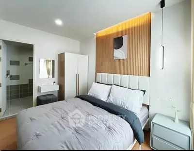 Modern bedroom with stylish decor and ensuite bathroom in a contemporary apartment.