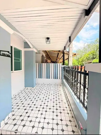 Charming covered patio with stylish tile flooring and elegant railing, perfect for outdoor relaxation.