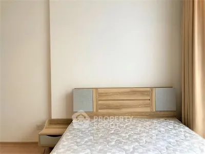 Modern minimalist bedroom with wooden bed frame and neutral decor.