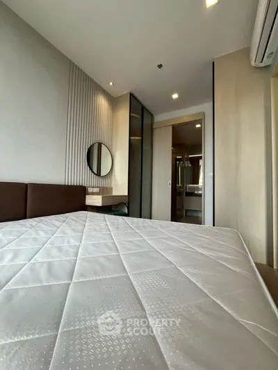 Modern bedroom with stylish decor and ensuite bathroom in a contemporary apartment.