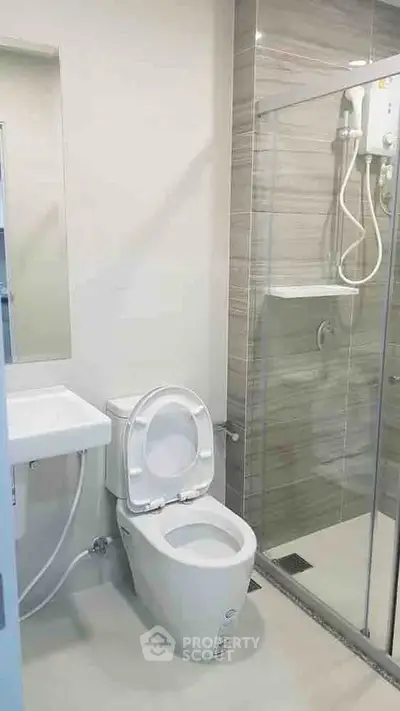 Modern bathroom with sleek shower and toilet in contemporary apartment.