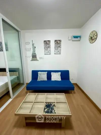 Modern living room with blue sofa and stylish decor in a cozy apartment.