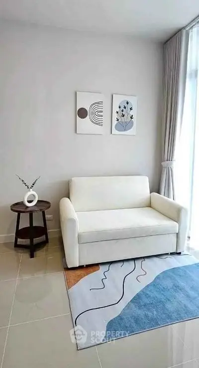 Modern living room with white sofa, abstract art, and natural light