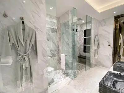 Luxurious marble bathroom with glass shower and elegant fixtures