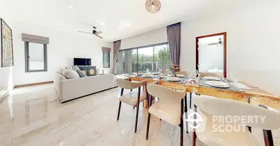 Spacious open-plan living and dining area with modern decor and large windows.