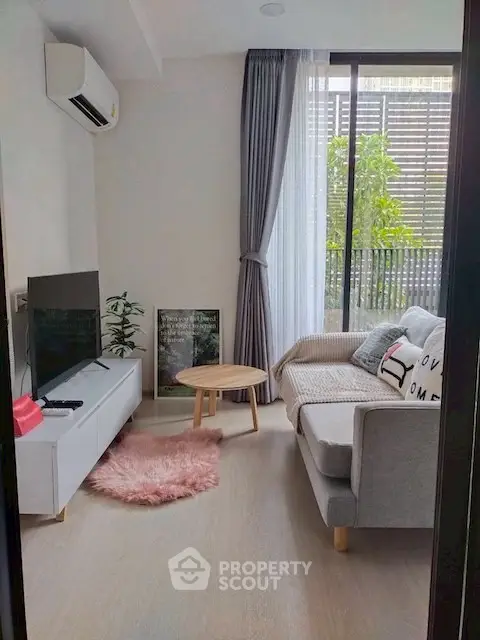 Cozy modern living room with stylish decor and large window view.