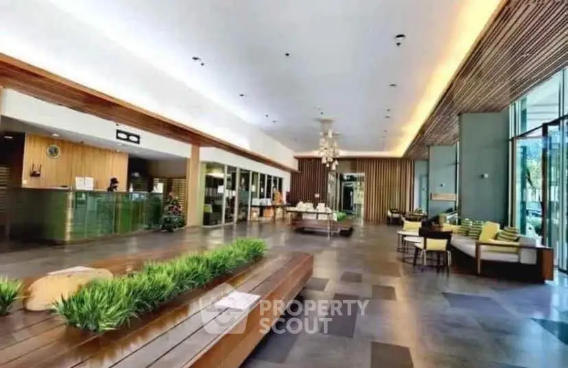 Luxurious modern lobby with stylish seating and greenery, perfect for welcoming guests in a high-end building.