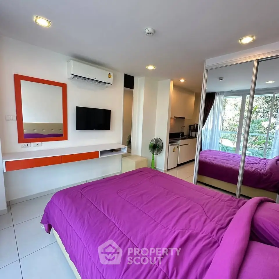 Modern bedroom with vibrant decor and mirrored closet in a stylish apartment.