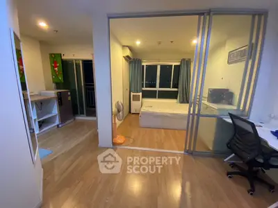 Modern apartment with sliding glass doors, wooden flooring, and city view.