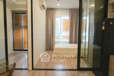Modern bedroom with glass sliding doors and natural light in a stylish apartment.