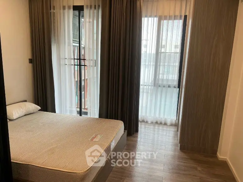Cozy bedroom with large windows and modern decor in a stylish apartment.