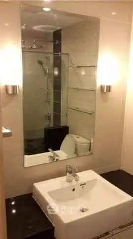 Modern bathroom with sleek fixtures and large mirror in a stylish apartment.