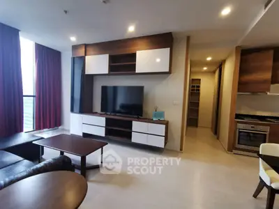 Modern living room with sleek furniture and open kitchen layout in a stylish apartment.