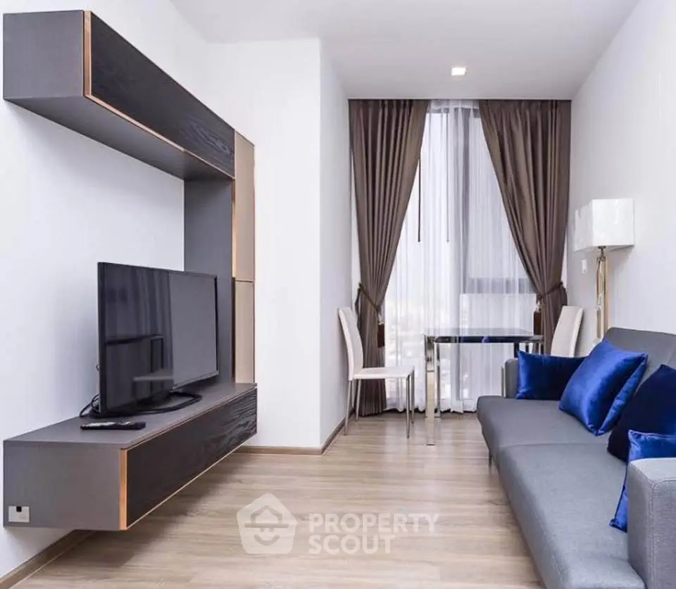 Modern living room with sleek furniture and large window, perfect for urban living.