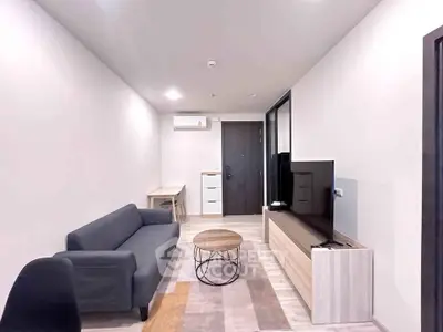 Modern living room with sleek furniture and neutral tones, featuring a cozy sofa and stylish TV unit.