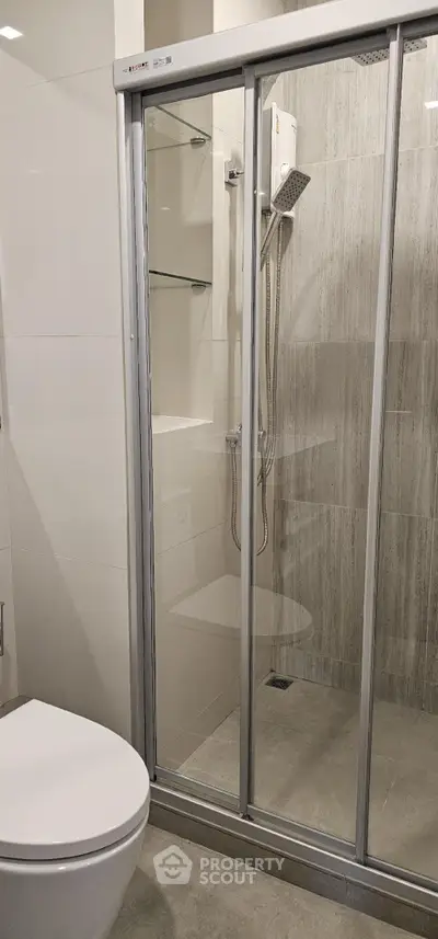 Modern bathroom with glass shower enclosure and sleek fixtures.